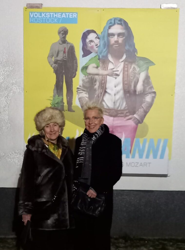 Zwei Frauen vor einem Plakat des Volkstheathers Rostock